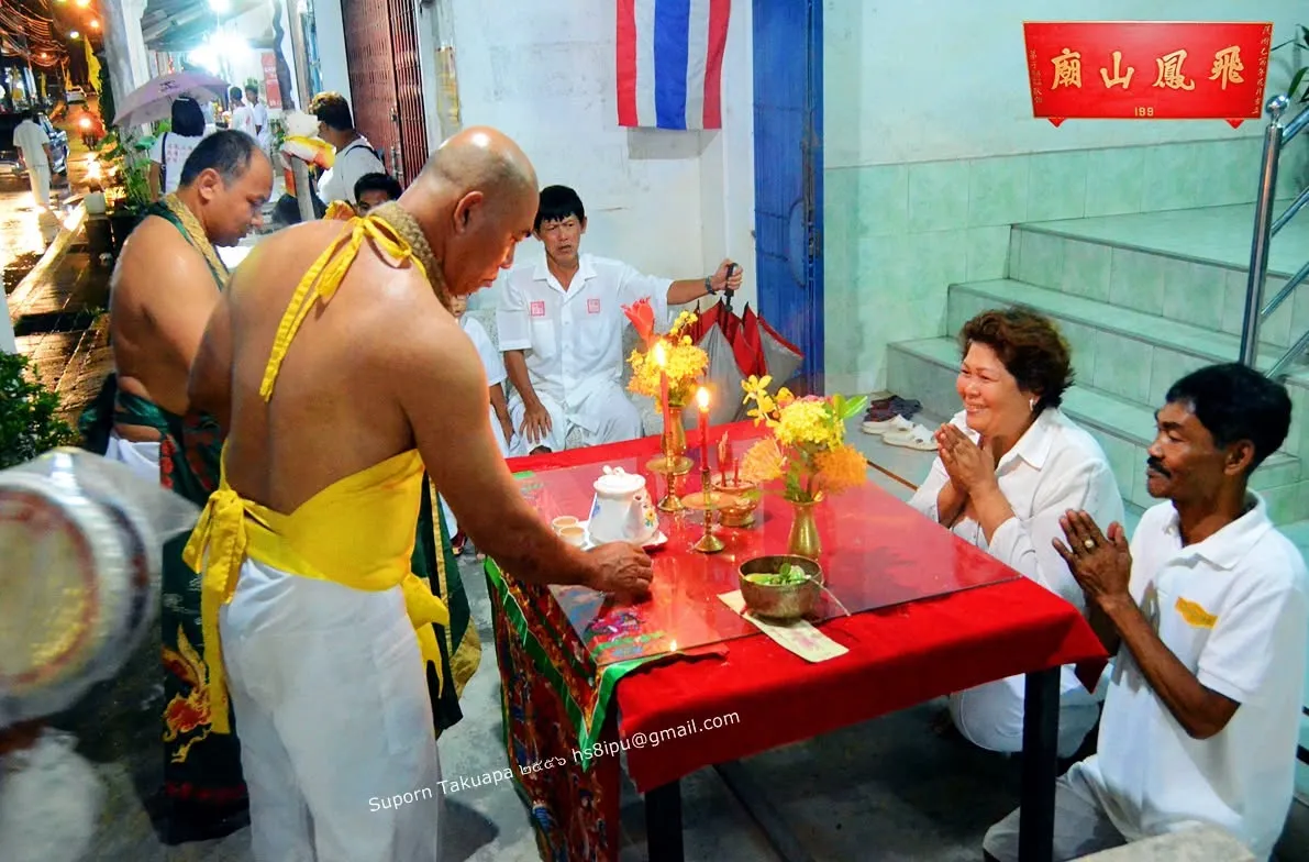 พิธีให้พรยามค่ำที่โต๊ะแดงหน้า มีเทียน ดอกไม้ และชุดน้ำชา