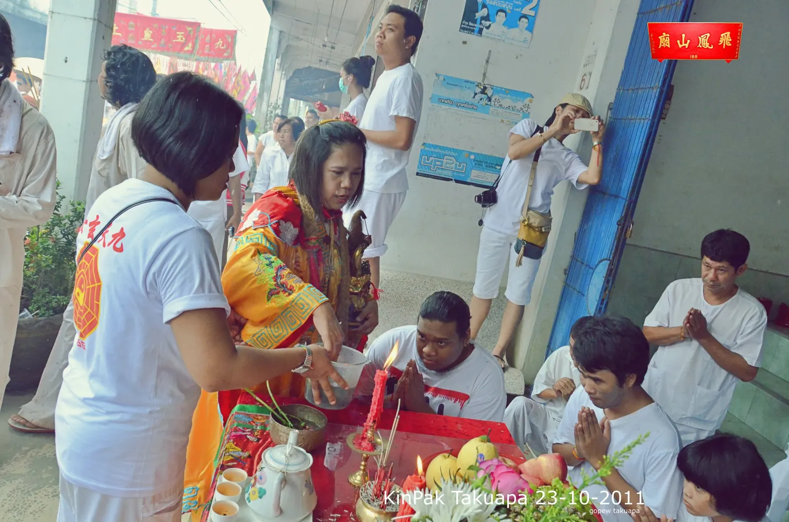 พิธีให้พรกลางวัน ผู้ศรัทธานั่งคุกเข่าพนมมือรอบโต๊ะบูชา
