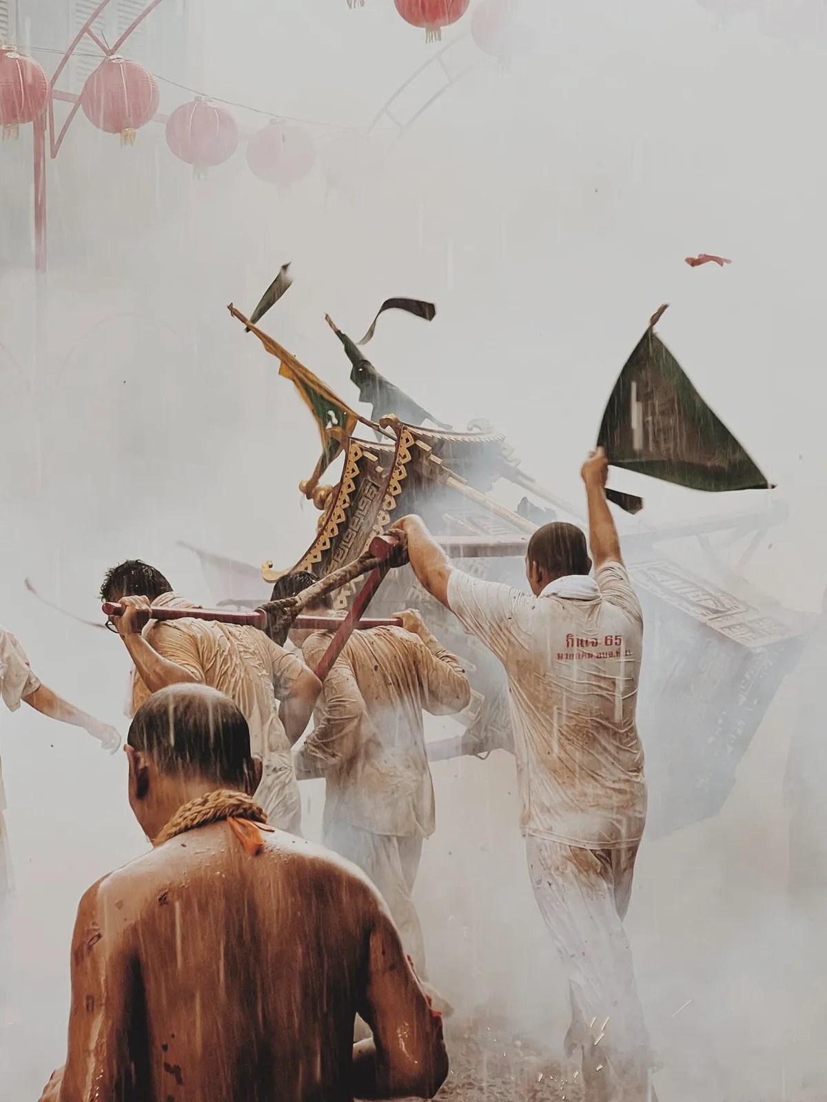 ผู้แบกเกี้ยวพระท่ามกลางควันและเสียงประทัด